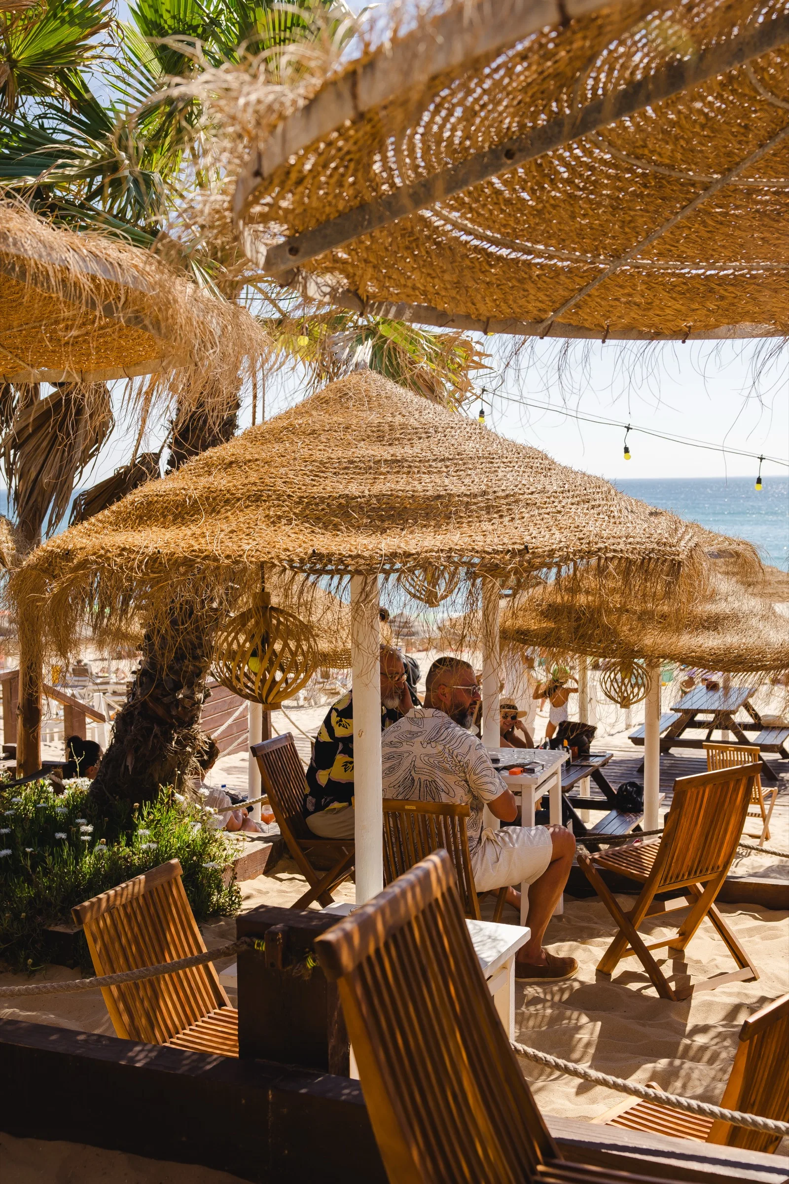 Mesas com os pés na Areia